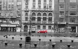 Red car racing down boulevard