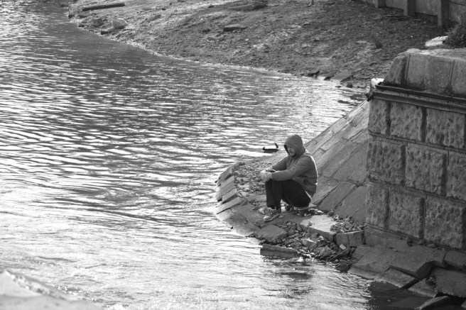 man meditating lakeshore