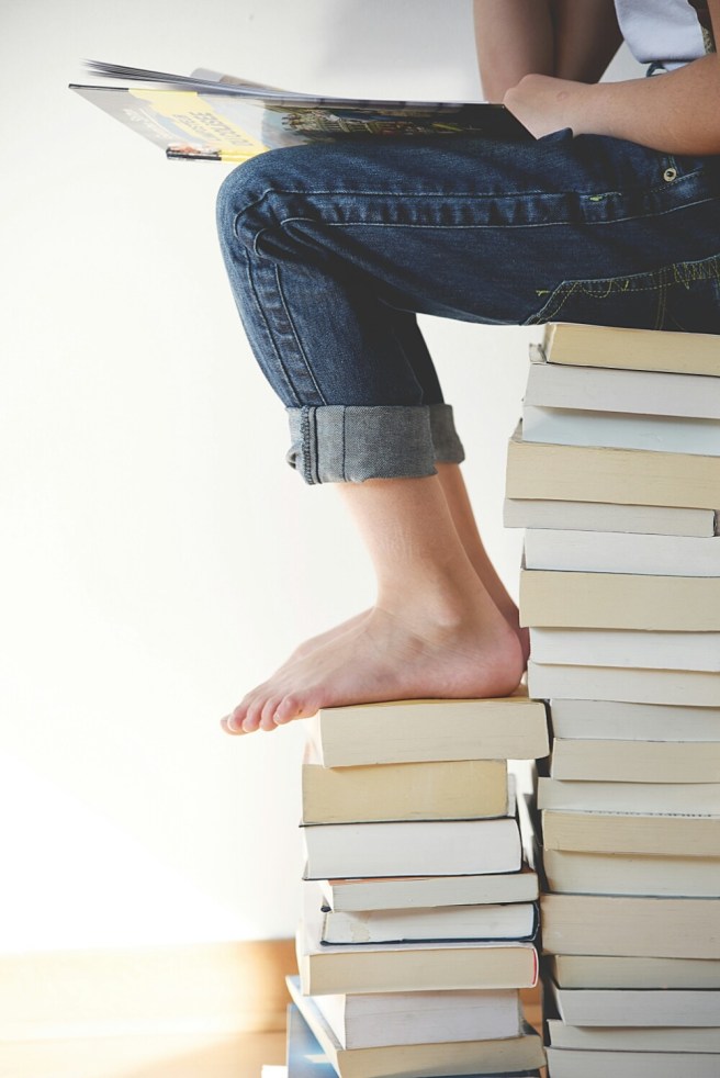 Woman reading stack of books