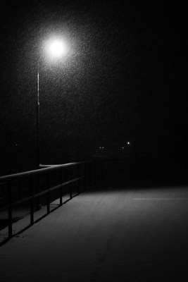 solitary stree lamp glowing in the dark above deserted platform winter landscape